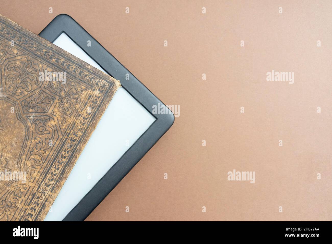 E-Reader, der aus einem sehr alten Buch mit schönen Einbände hervorgegangen ist Stockfoto