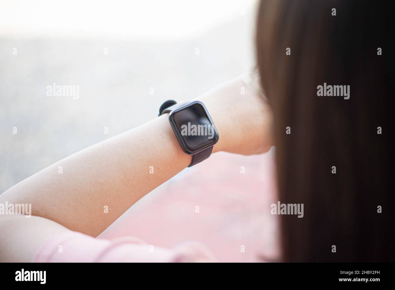 Nahaufnahme der schwarzen Smartwatch am Handgelenk einer asiatischen Frau. Und es gibt freien Platz zum Schreiben von Nachrichten. Concept Smartwatch im Lift-Stil. Stockfoto