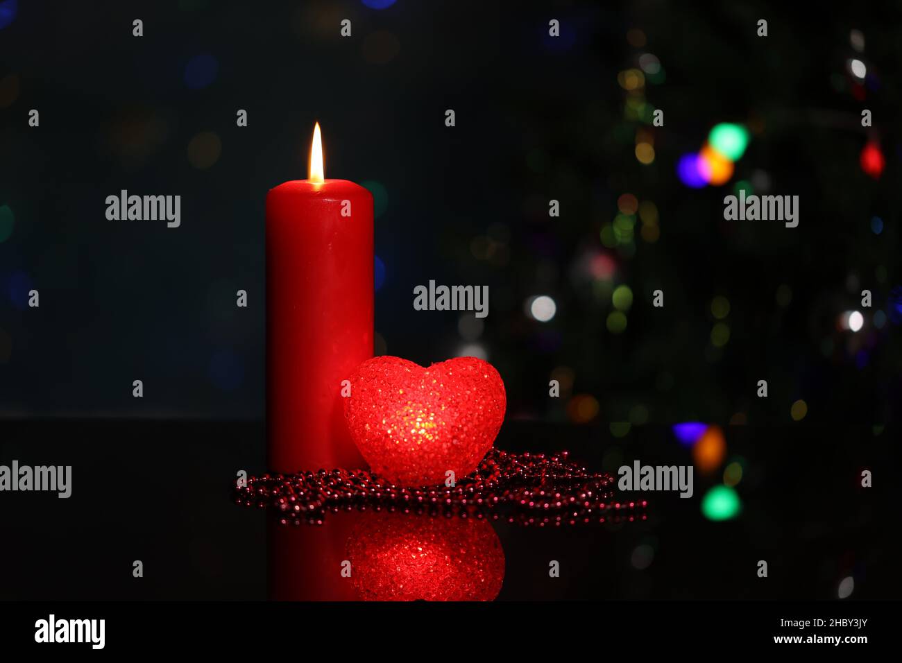 Weihnachtsdekoration mit brennenden Kerzen und dekorativem Herz. Stockfoto