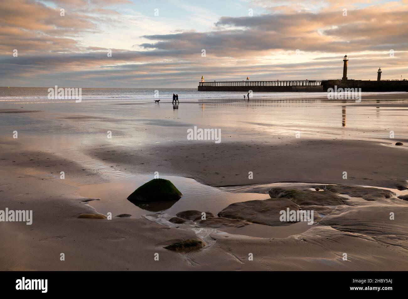 Spaziergänger am frühen Morgen am Strand, Whitby, North Yorkshire, Großbritannien Stockfoto