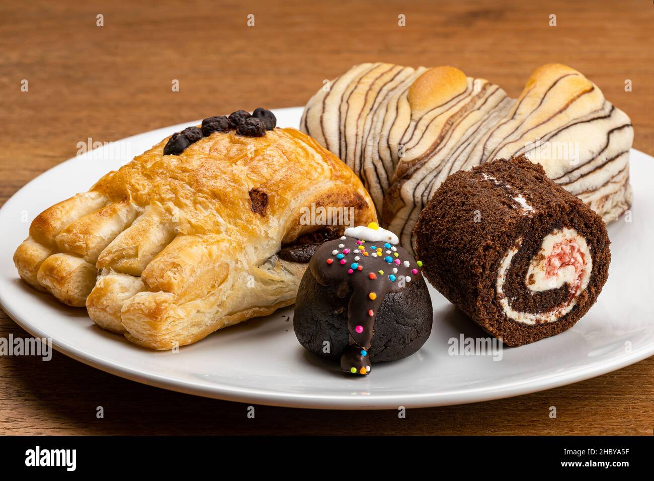 Variation aus köstlichem Dessert, dänischem Gebäck mit Schokoladencreme-Füllung, Schokoladenbrot, Schwarzwälder Schokoladenrolle und Choc Balls toppi Stockfoto