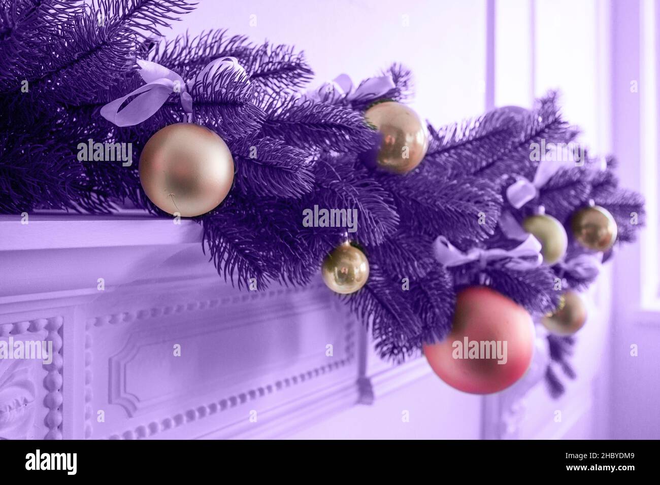 Ein Zweig eines Weihnachtsbaums mit Weihnachtsspielzeug in pantone-Farbe. Horizontales Foto. Stockfoto