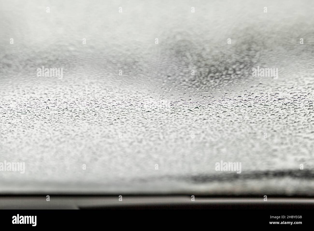 Wassertropfen auf dem Glas eines Autos im Winter, Frühling oder Herbst. Stockfoto