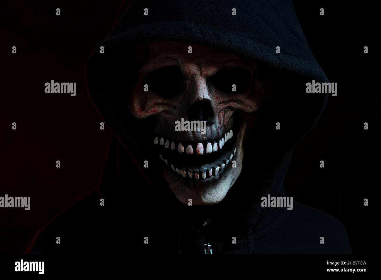 Die Totenkopf Maske mit Kapuzenhemd im dunklen Hintergrund. Stockfoto