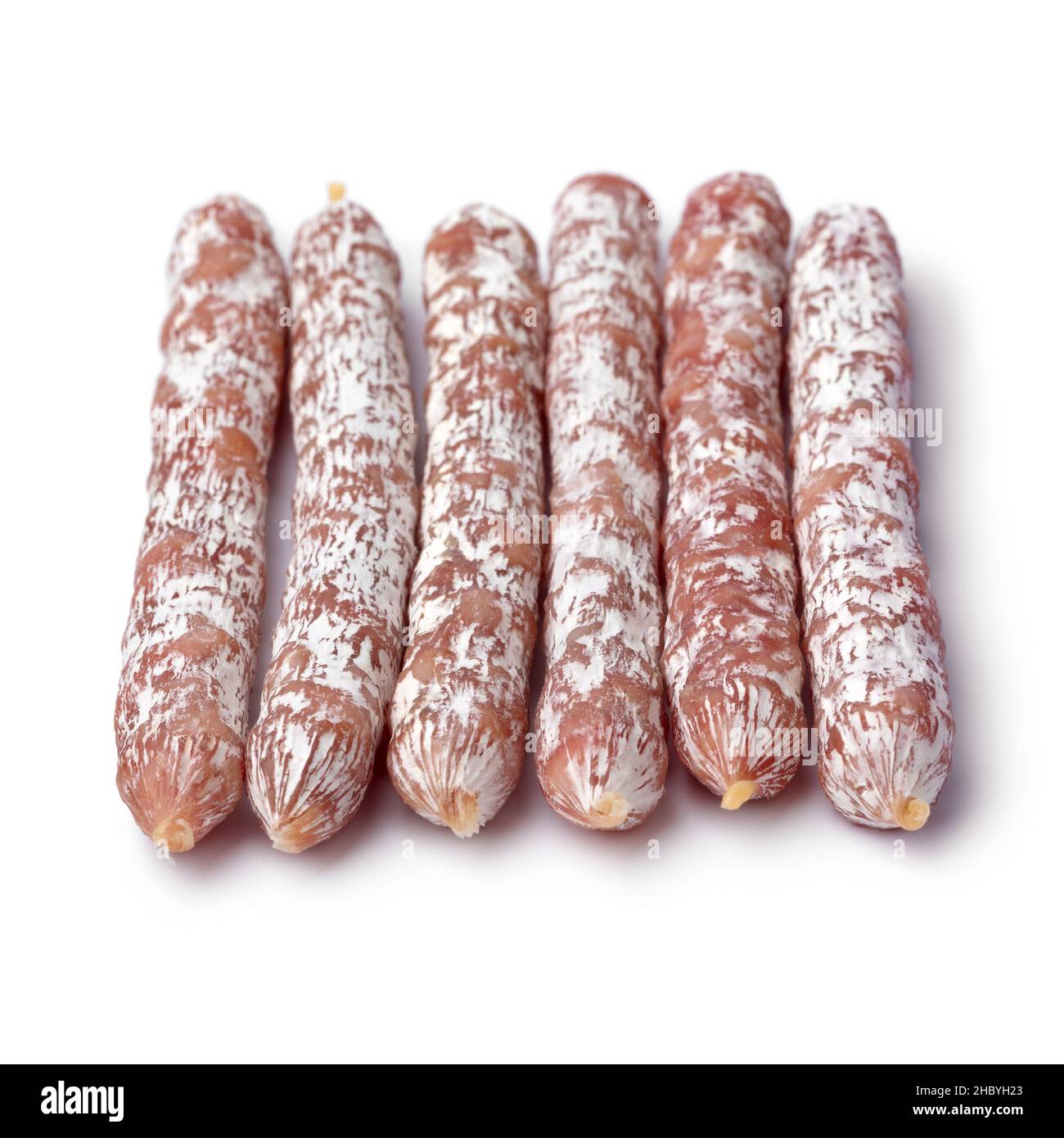 Eine Reihe von trockenen geräucherten Salami-Stäbchen aus der Nähe für einen Snack isoliert auf weißem Hintergrund Stockfoto