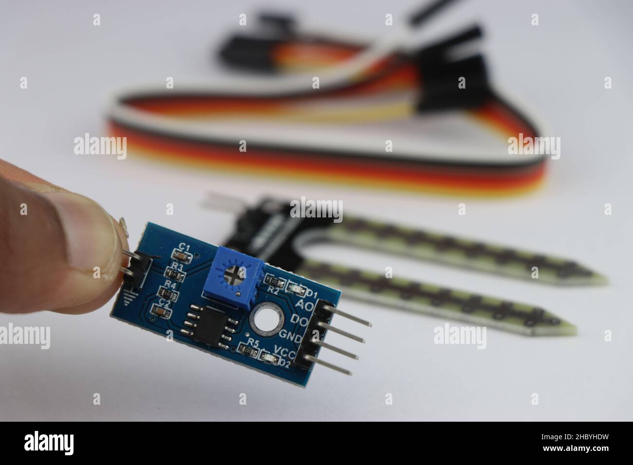 Analog-Digital-Signalwandler für Bodenfeuchtigkeitsdetektionssensor mit Sensor und Drähten im Hintergrund Stockfoto