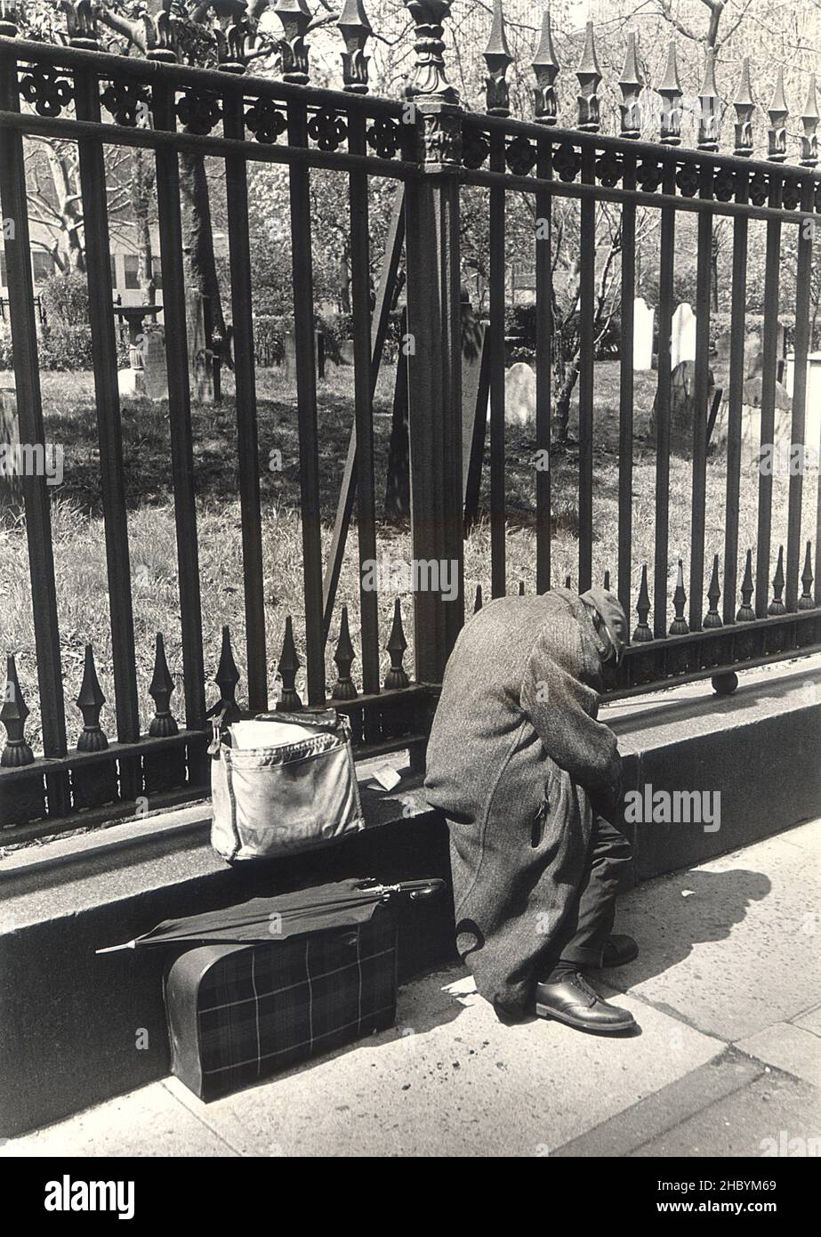 Obdachloser mit seinen Habseligkeiten ruht vor der Trinity Church am unteren Broadway in Manhattan, New York City. Stockfoto