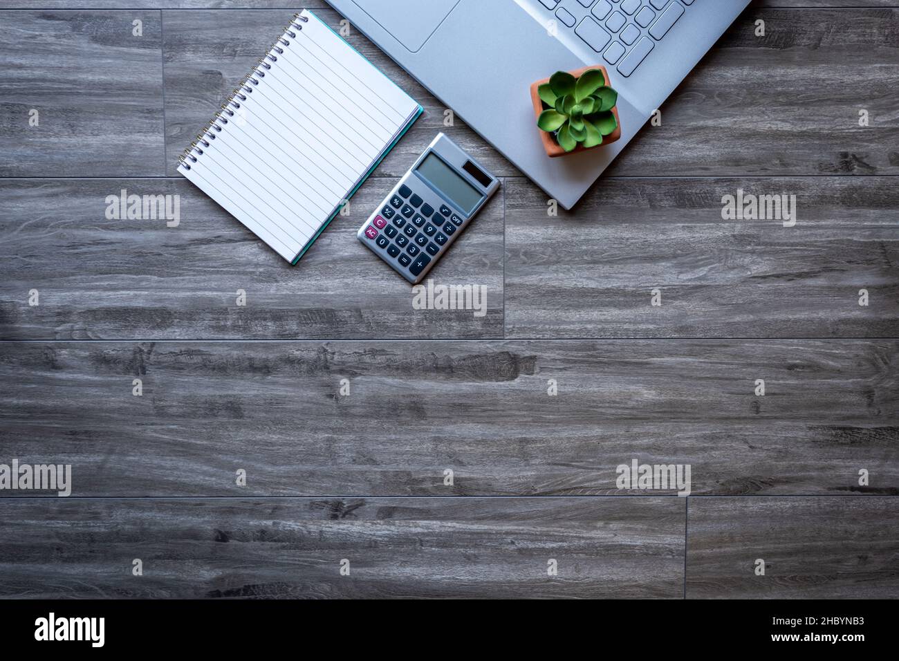 Grauer Schreibtisch aus Holz, Arbeitsbereich mit Laptop-Computer und Zubehör für geschäftliche und ferngesteuerte Arbeit von zu Hause aus. Draufsicht mit Kopierbereich flach liegend. Stockfoto