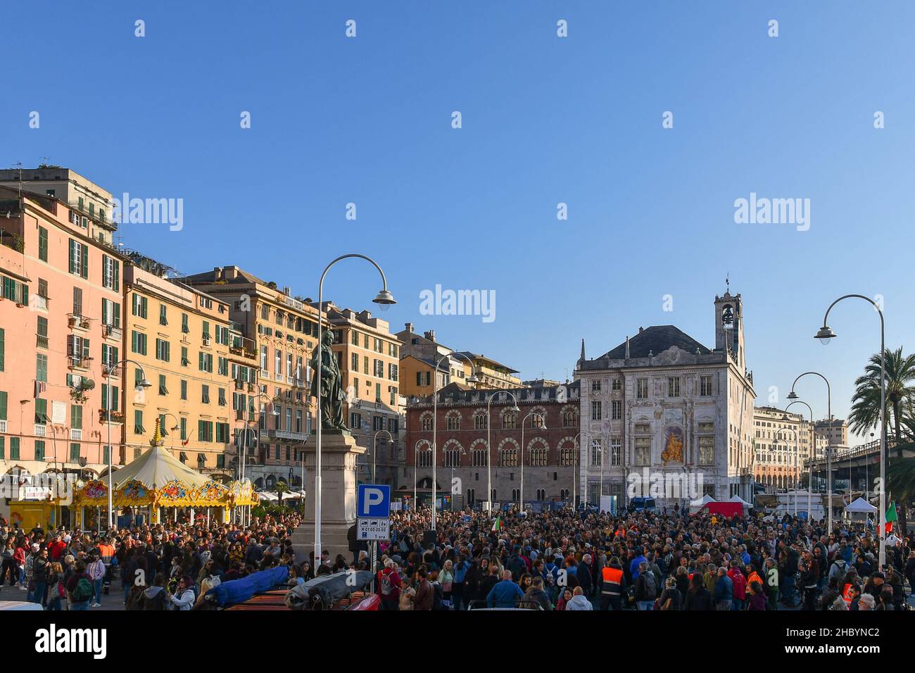 Genua, Ligurien, Italien - 10 23 2021: Menschenmenge bei einer Protestkundgebung ohne Green Pass auf der Piazza Caricamento mit dem Palazzo San Giorgio im Hintergrund Stockfoto