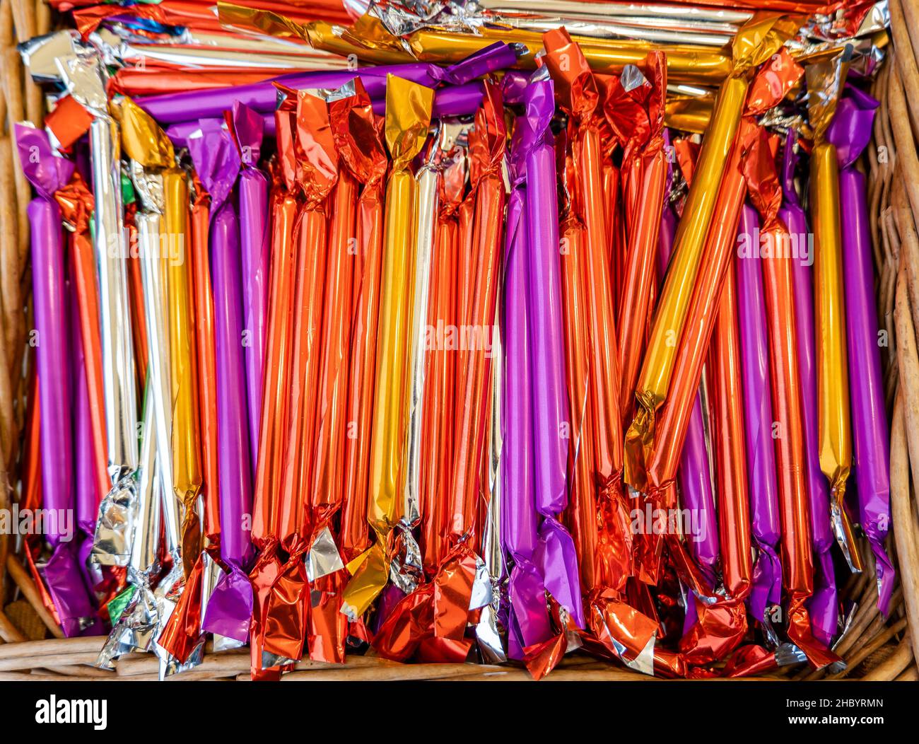 Viele polnische Weihnachtsbonbons, gerader, rohrförmiger traditioneller süßer zuckerhaltiger Snack, viele Retro-Süßigkeiten der Saison, verpackt in glänzendem Kol Stockfoto