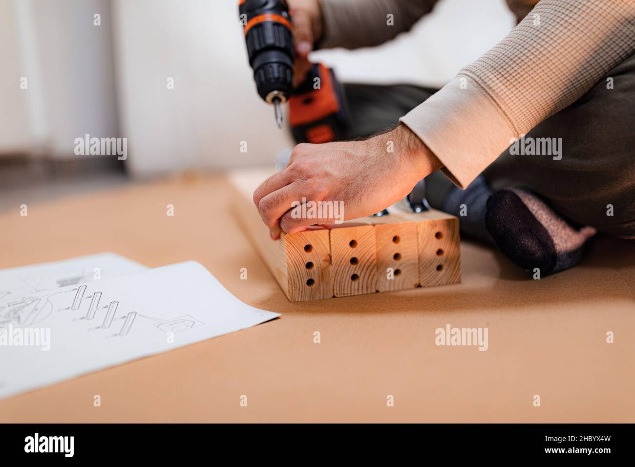 Mann, der an einer neuen Bettanlage arbeitet und einen Akku-Bohrschrauber verwendet Stockfoto