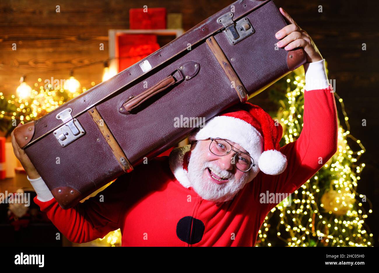 Weihnachtsfeiertage. Reisen, Tourismus, Urlaub. Weihnachtsmann mit Koffer. Weihnachtsmann mit Gepäck unterwegs. Stockfoto