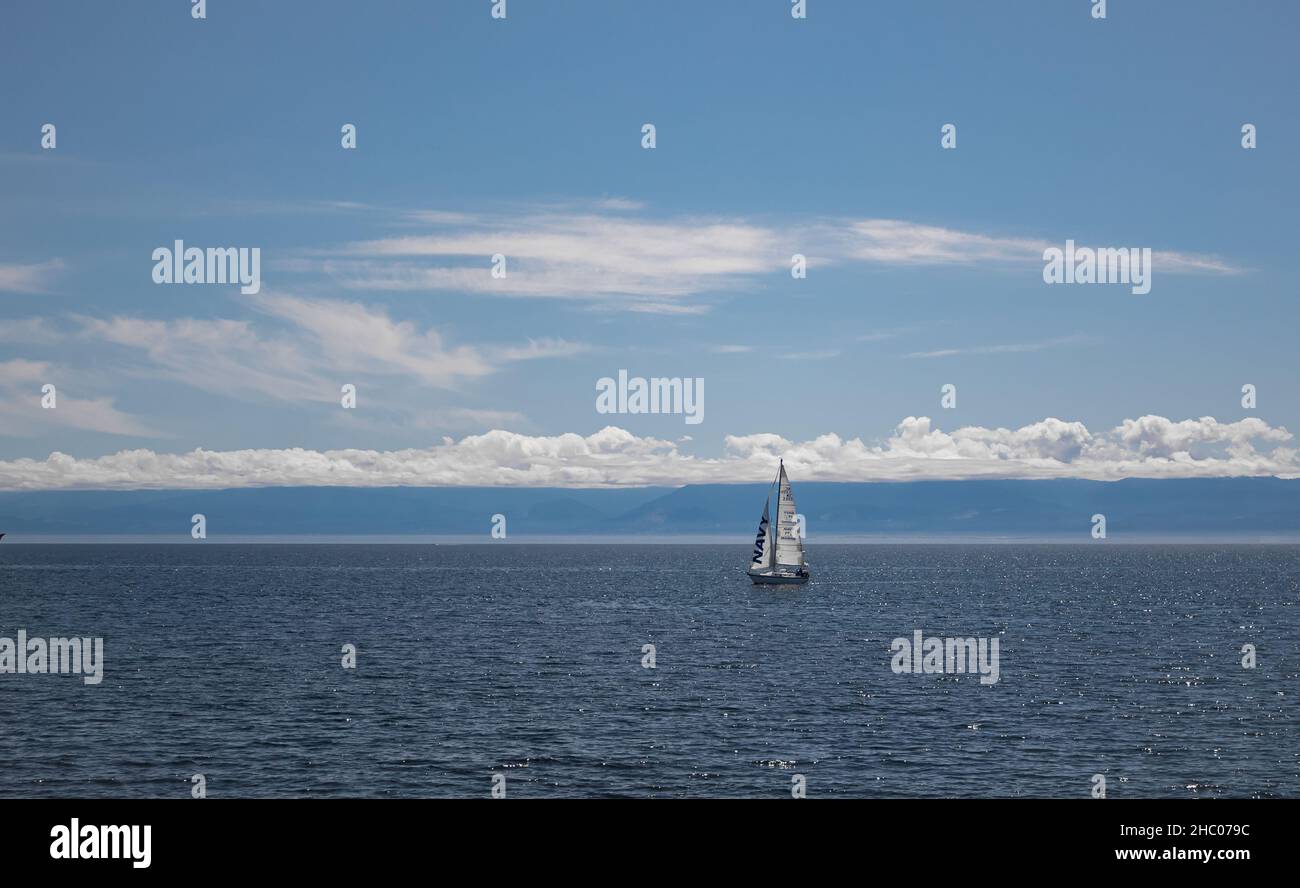 Einsame Yacht mit weißem Segel im offenen Meer. Segelboot im Pazifischen Ozean in der Nähe von Vancouver Island, BC Stockfoto