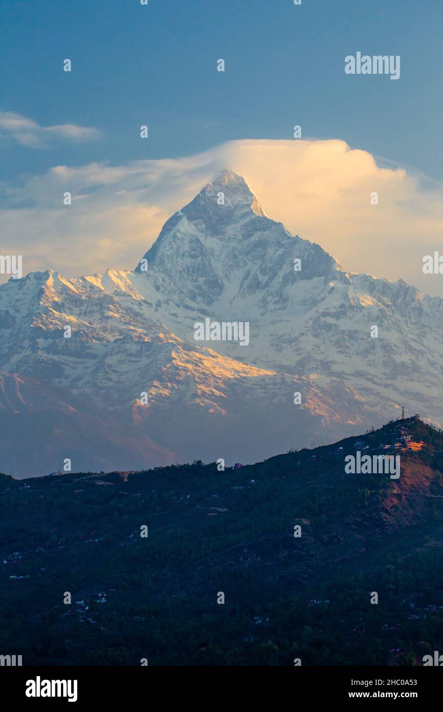 Erstes Licht bei Sonnenaufgang auf Machhapuchare im nepalesischen Himalaya bei Pokhara, Nepal. Sarangkot Hügel ist im Vordergrund. Stockfoto