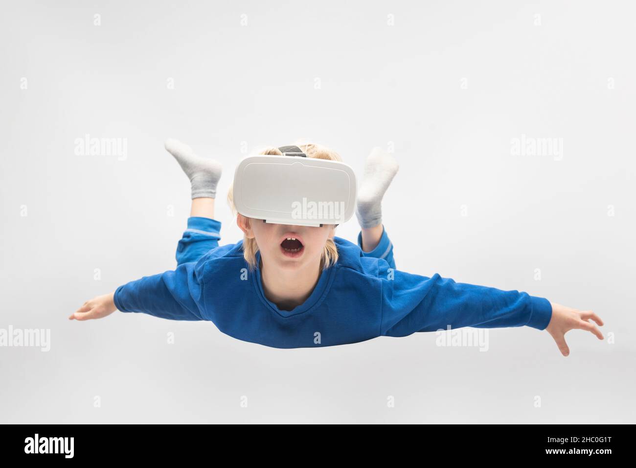 Junge fliegt in einer Virtual-Reality-Brille. Weißer Hintergrund. Virtual-Reality-Spiele. Stockfoto