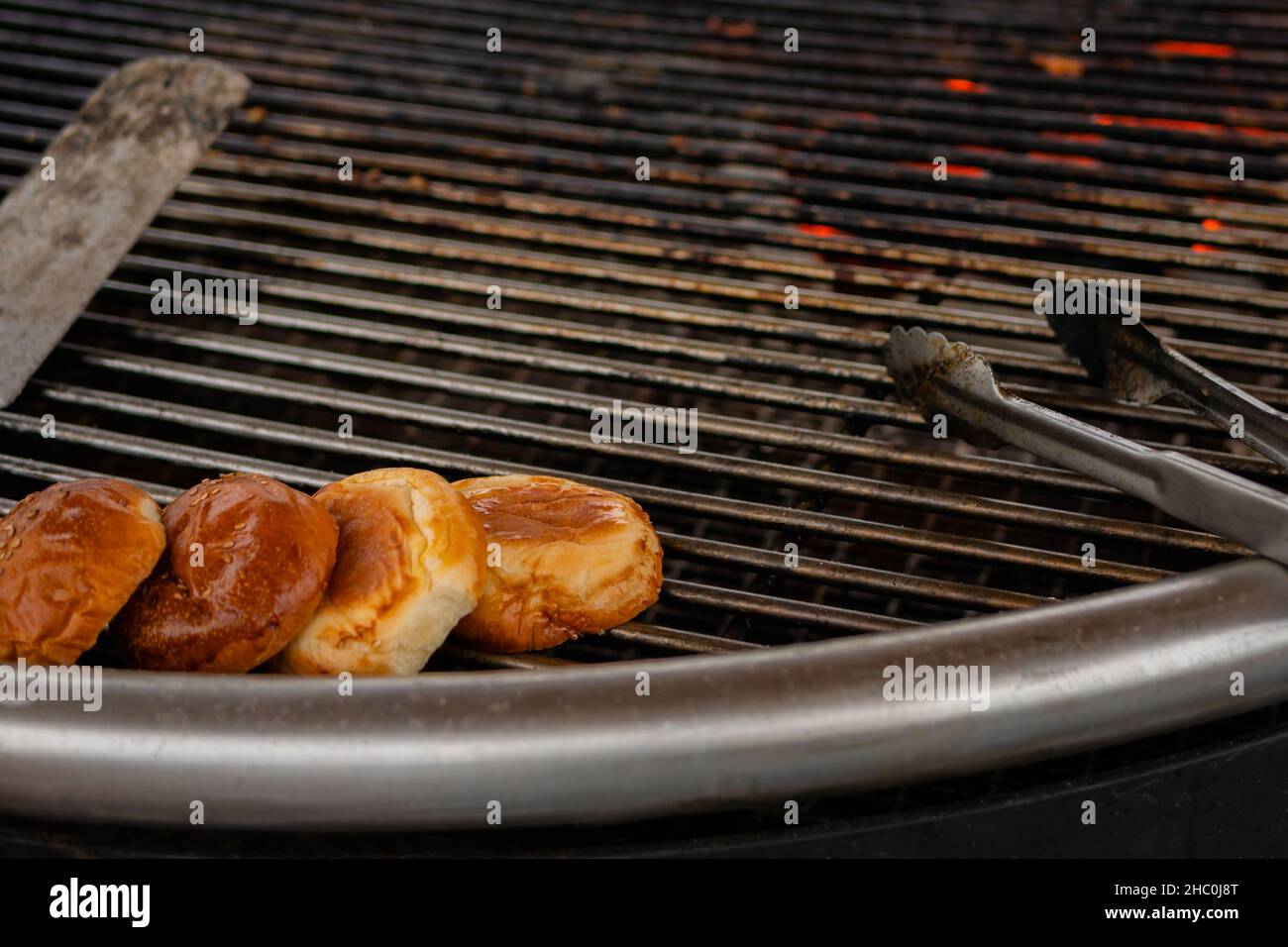 Prozess der Zubereitung von Buns für Burger auf dem Grill im Sommer lokalen Lebensmittelmarkt Stockfoto