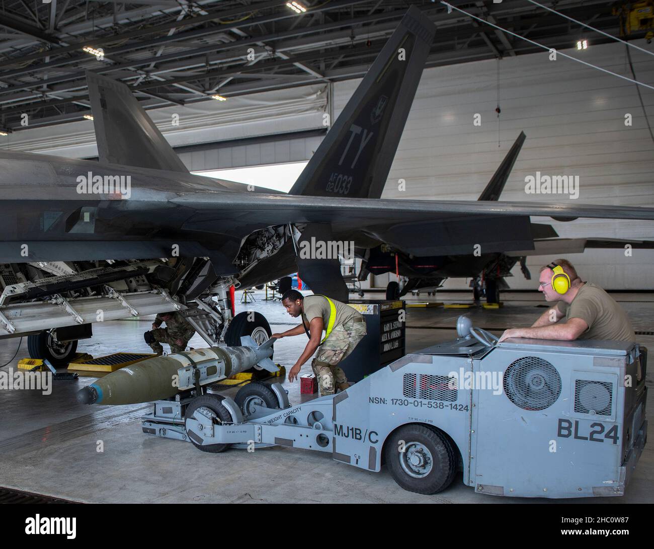 Eine 43rd Fighter Generation Squadron Lastmannschaft bewegt eine GBU-32 zu ihrem F-22 Raptor während des Waffenlastwettbewerbs der Einheit am 17. Dezember auf der Eglin Air Force Base, Fla. Zwei Mannschaften wetteiferten um zu sehen, wer am schnellsten und mit den wenigsten Fehlern ein AIM-120 und ein AIM-9 auf ihr Flugzeug laden konnte. Der Gewinner wird bei der Preisverleihung für das Quartal 4th bekannt gegeben. (USA Luftwaffe Foto/Ilka Cole) Stockfoto