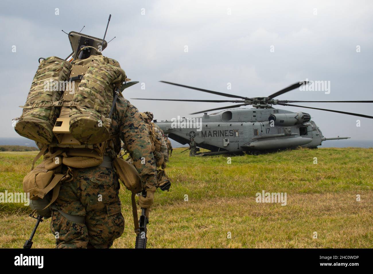 U.S. Marinesoldaten mit Bataillon Landing Team 1/5, 31st Marine Expeditionary Unit (MEU), Ladung in einen CH-53E Superhengst mit Marine Medium Tiltrotor Squadron 265 (rein.), 31st MEU, nach einem Hubschrauberraz während der MEU Übung (MEUEX) auf IE Shima, Okinawa, Japan, 17. Dezember 2021. Übungen wie Hubschrauberangriffe verstärken die Lehre des Marine Corps von einer einsatzbereiten und mobilen Kraft, die schnell reagieren kann. MEUEX ist eine Schulung vor der Bereitstellung, die die Missionsfähigkeiten des MEU in allen untergeordneten Elementen der Marine validiert und stärkt. Die 31st MEU, der einzige Nachteil des Marine Corps Stockfoto