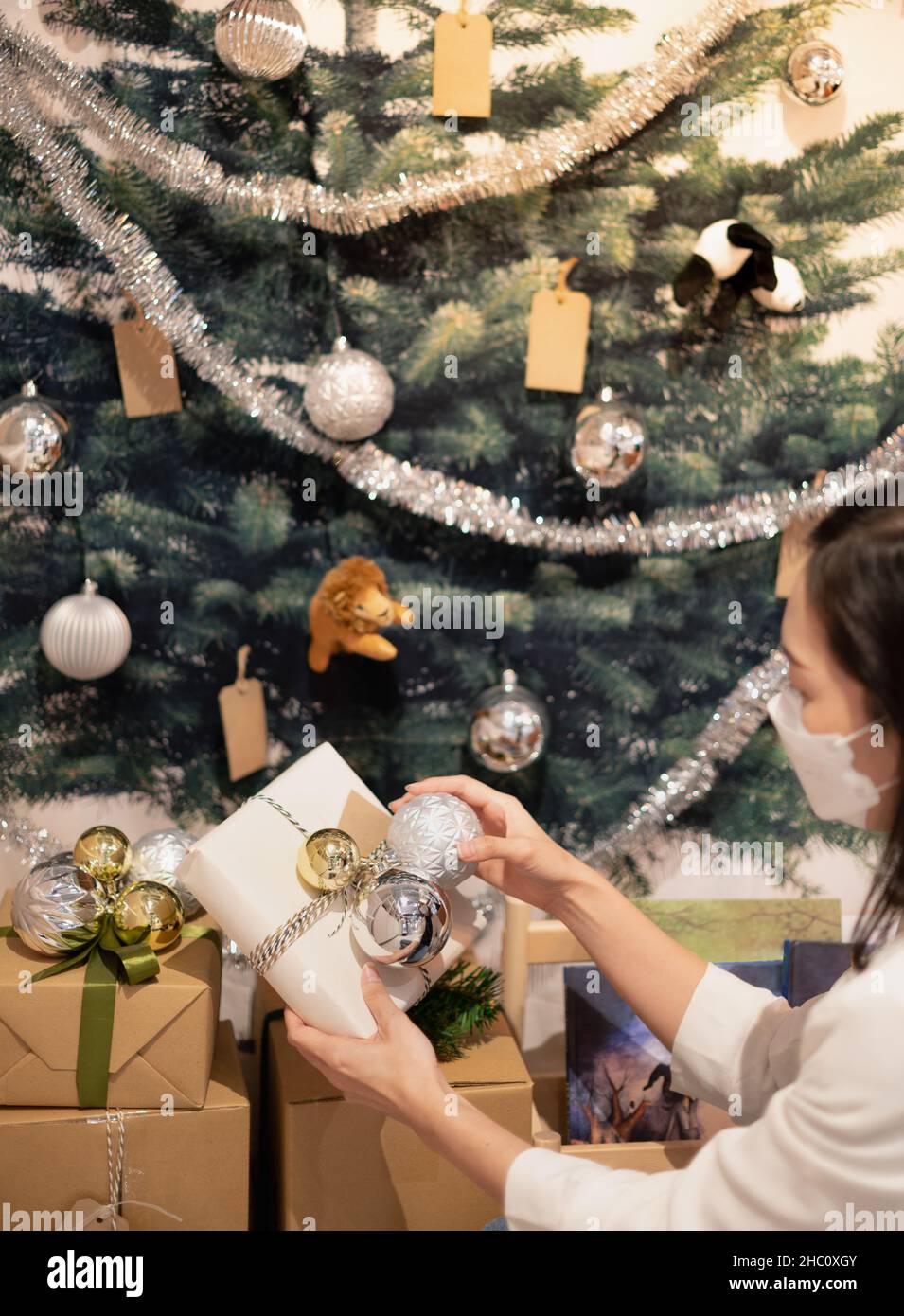 Weibliche Hände halten Weihnachten Geschenk-Box mit Gold-und Silberkugel Weihnachtsschmuck für Weihnachten und Neujahr Feier und Dekoration. Stockfoto