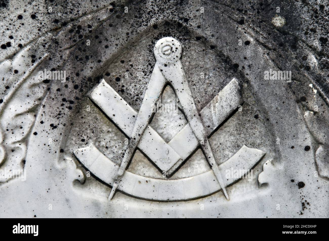 Hintergrund eines verwitterten und mit Flechten verkrusteten Freimaurersymbols auf einem Grabstein Stockfoto