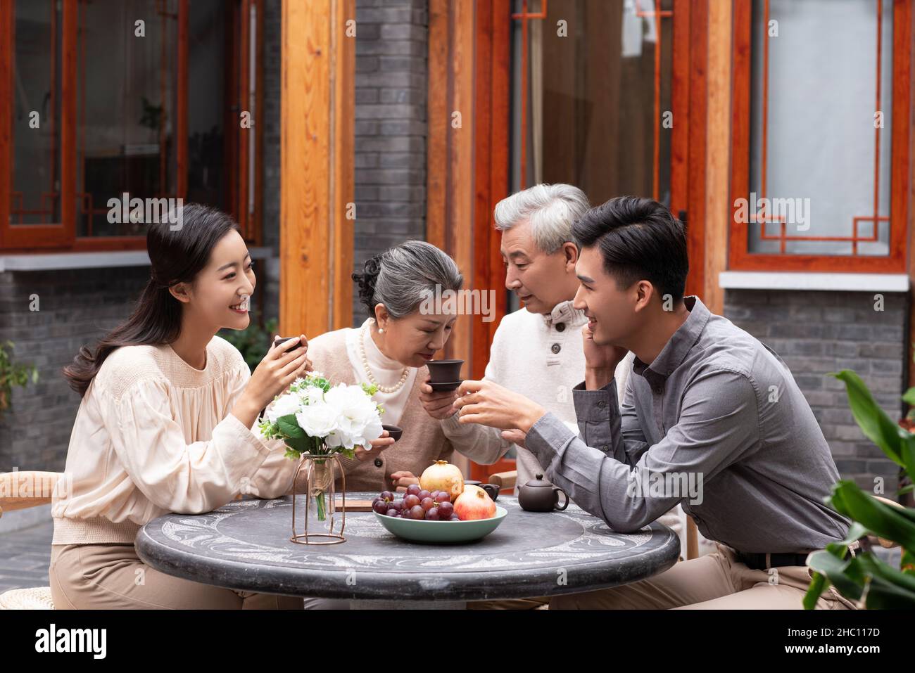 Glückliche Familien, die Tee trinken und im Innenhof plaudern Stockfoto