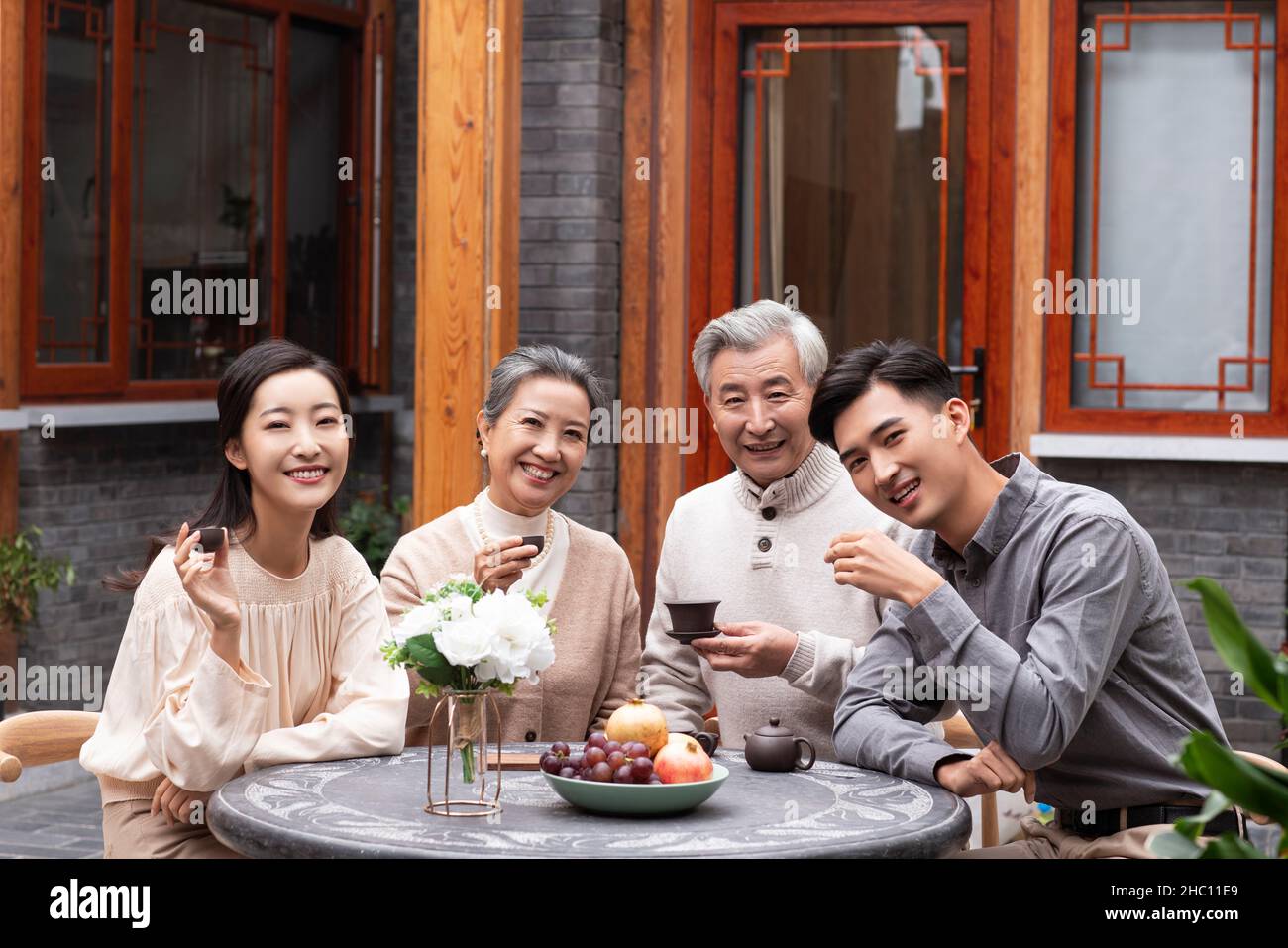 Glückliche Familien, die Tee trinken und im Innenhof plaudern Stockfoto