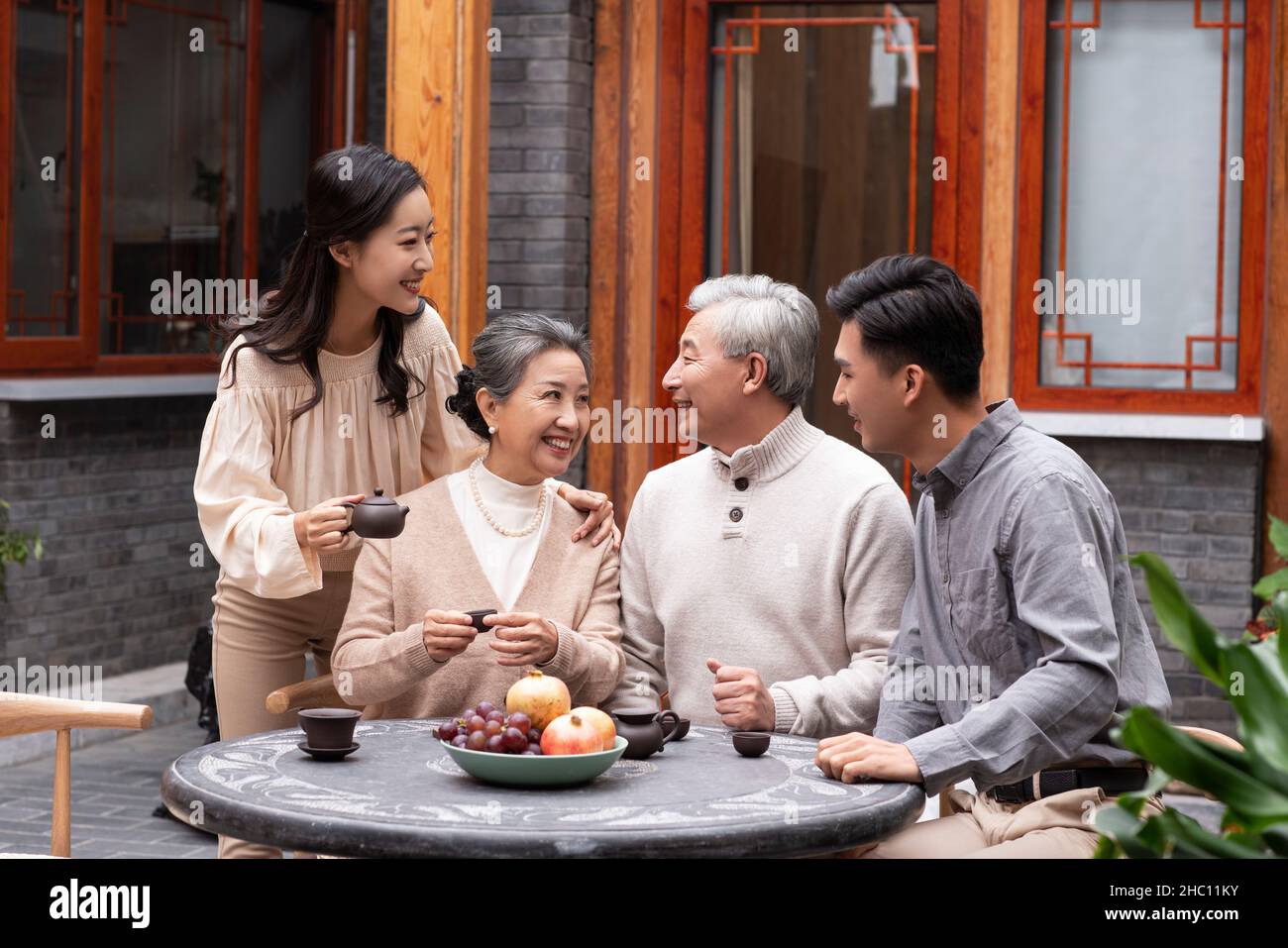 Glückliche Familien, die Tee trinken und im Innenhof plaudern Stockfoto