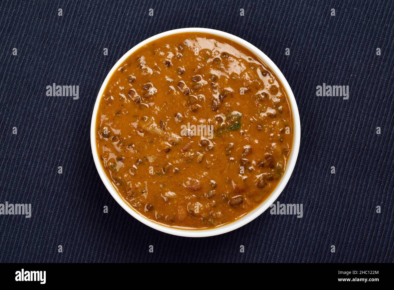 Draufsicht auf Dal Makhani in „Bowl Against Blue“-Geschirrtuch Stockfoto