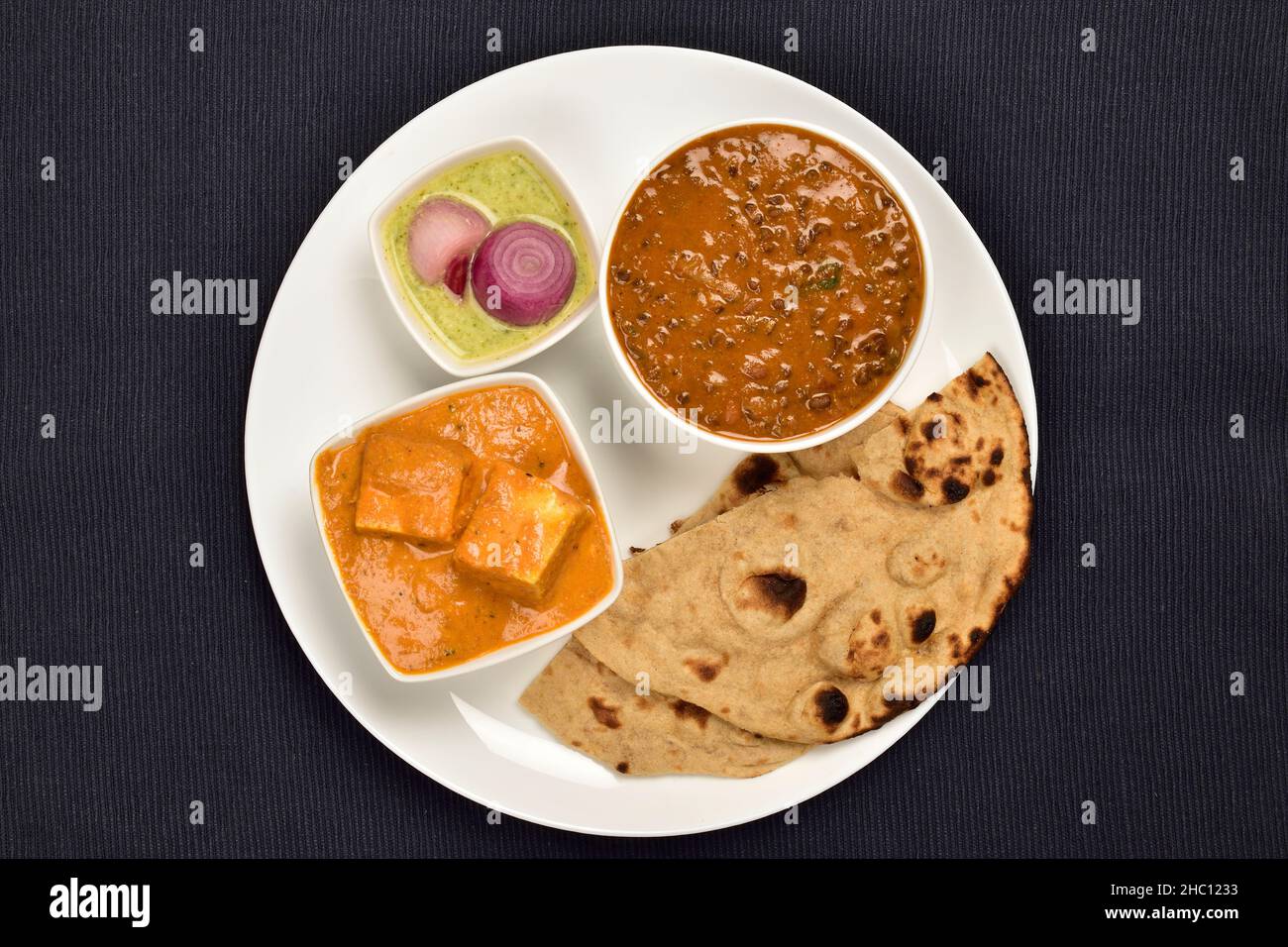 Teller mit indischem Hauptgericht, Dal Makhani und Paneer Butter Masala serviert mit Tandoori Roti und Chutney Stockfoto