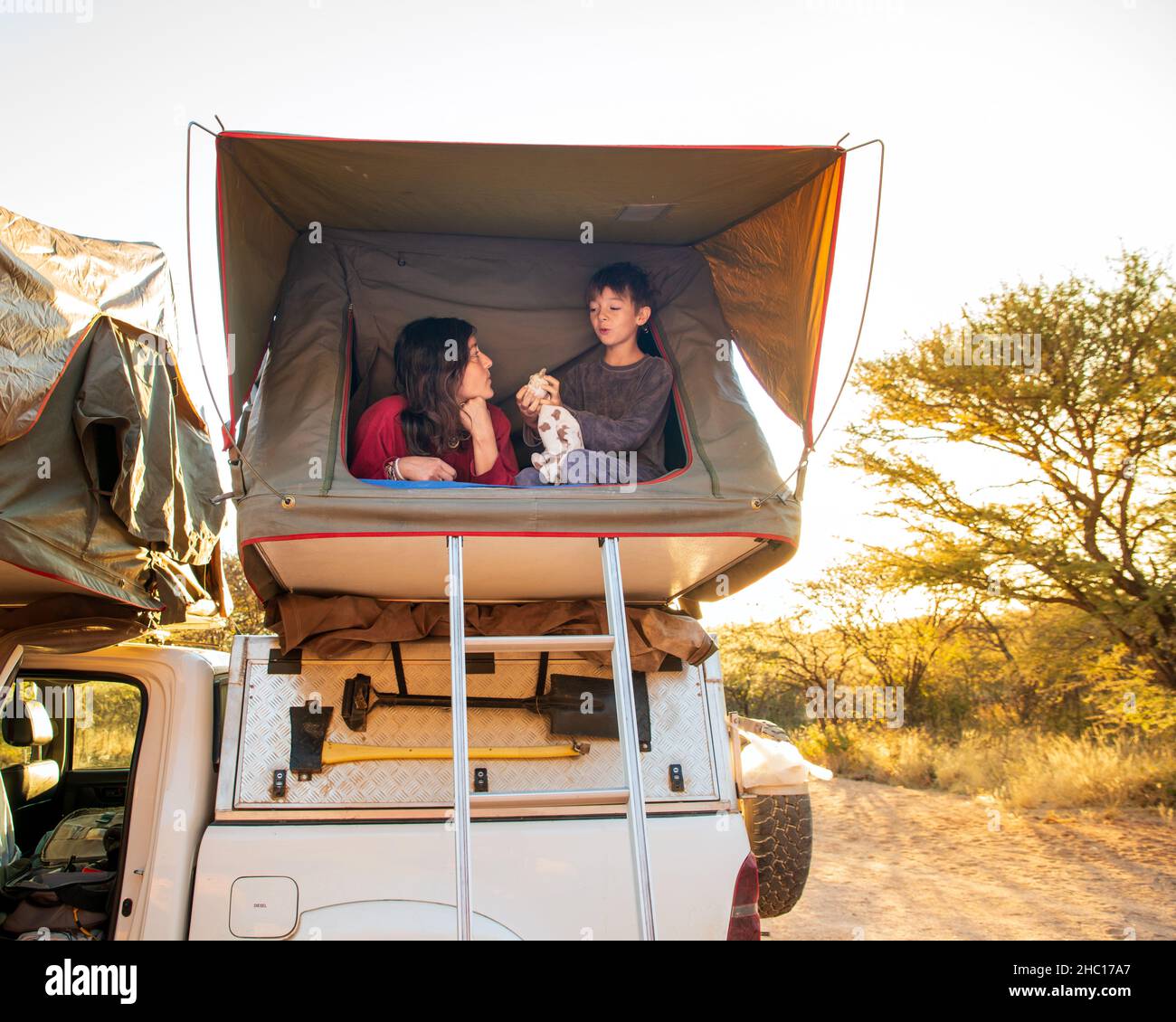Mutter und Sohn in einem Dachzelt in Afrika Stockfoto