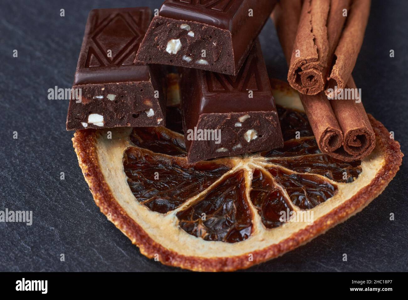 Dunkle Schokoriegel mit gehackten Mandeln, getrocknete Orangenkeile Stockfoto