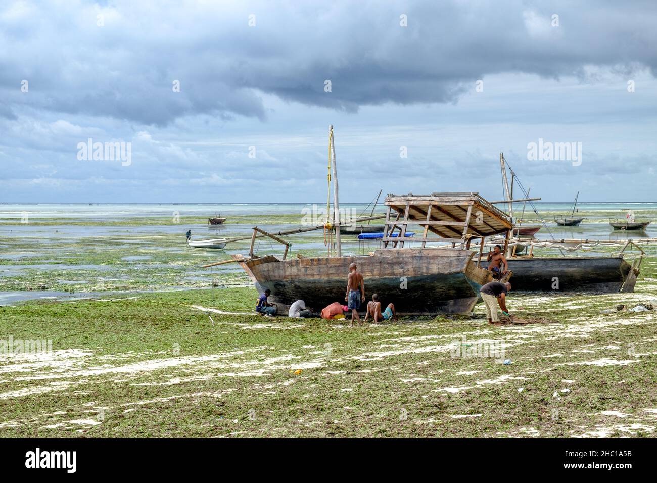 Fischer reparieren ihre Daus an den weißen Stränden von Sansibar Stockfoto