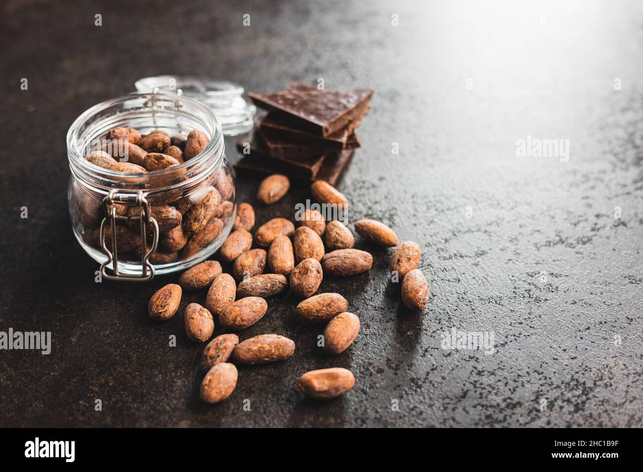 Getrocknete Kakaobohnen. Kakaobohnen im Glas auf Küchentisch. Stockfoto