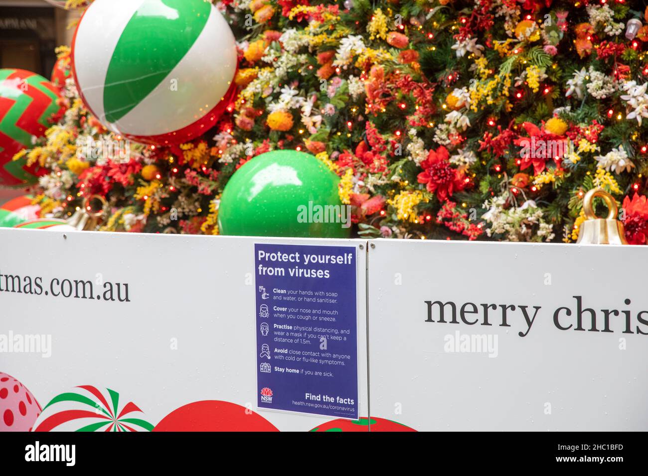Gesundheitsberatung in Sydney Schützen Sie sich neben dem öffentlichen Weihnachtsbaum im Martin Place vor Viren, wie omicron-Fälle es fordern, Sydney, Australien Stockfoto