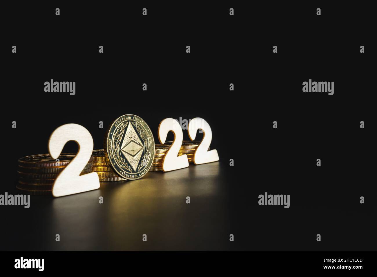 Ethereum in 2022 Preisvorhersage Konzept. Einzelne Äther-Goldmünze neben den weißen Jahreszahlen auf schwarzem Hintergrund mit Platz für Text. Stockfoto