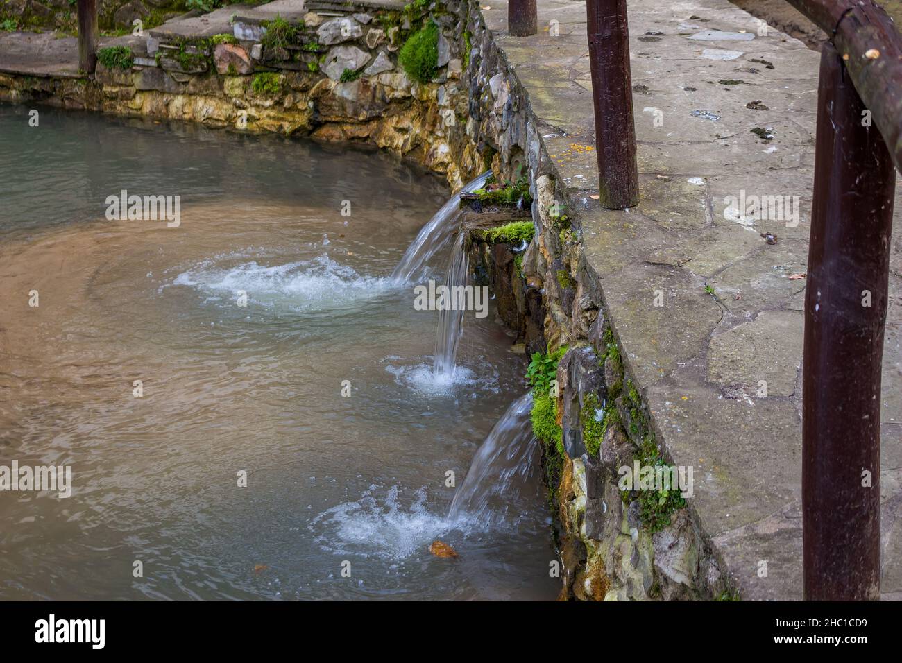 Ein Abfluss zur Regulierung des Wasserstands in den Reservoirs. Kleine Wasserfälle im Landschaftsdesign Stockfoto