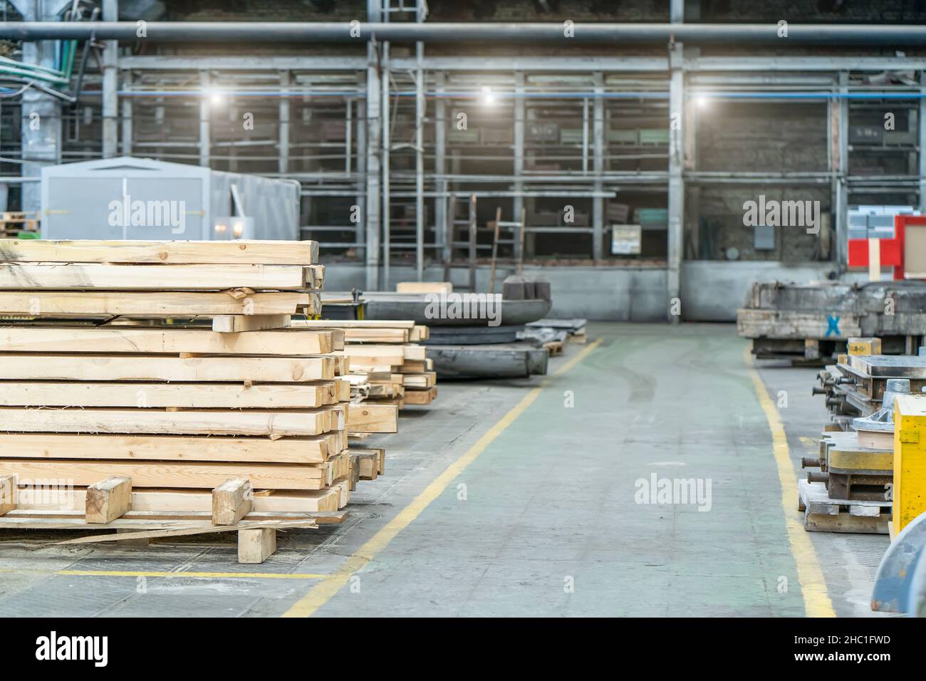 Im Inneren der riesigen holzverarbeitenden Industriefabrik mit Holzstapeln. Stockfoto