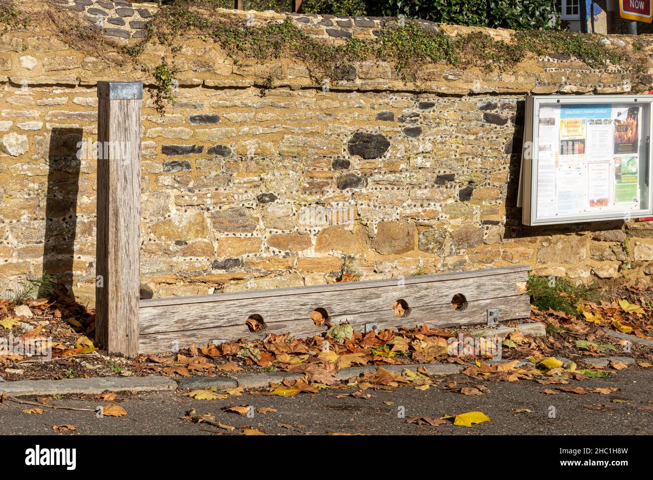 Stock and Whipping Post, Dorfbestände neben der Kirchenmauer in Shalford, Surrey, England, Großbritannien Stockfoto