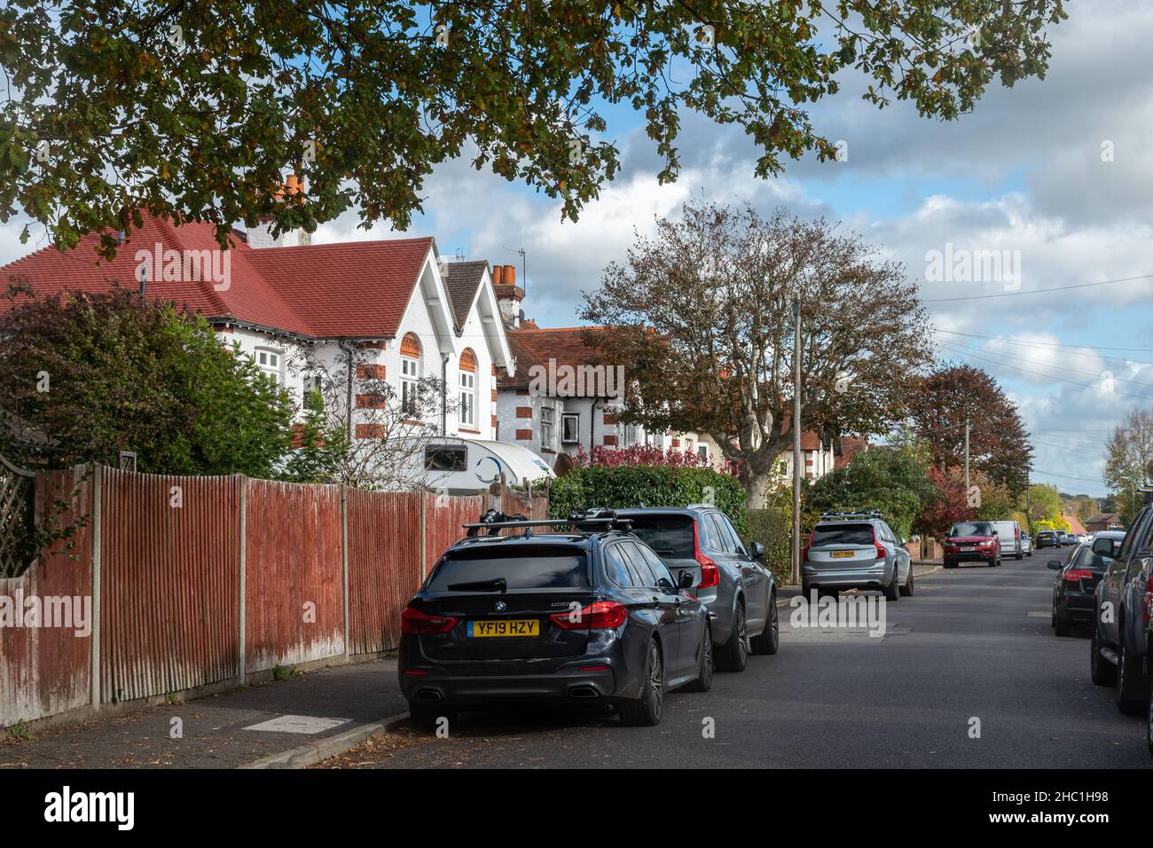 Typischer Blick auf die Straße von Surrey. Tillingbourne Road in Shalford Village, Surrey, England, Großbritannien, mit Häusern Eigenschaften und geparkten Autos. Stockfoto