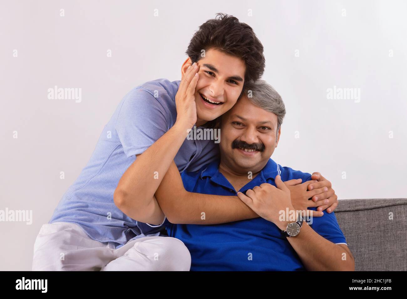 Indischer Vater und Sohn lieben sich gegenseitig, während sie auf dem Sofa sitzen Stockfoto