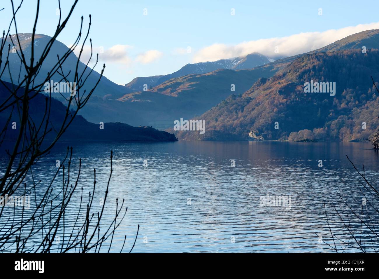 Blick auf den See von Ullswater in Cumbria The Lake District Nation Park. Morgenlicht, Blick fällt mit einem leichten Nebel. Blaue Reflexe. Stockfoto