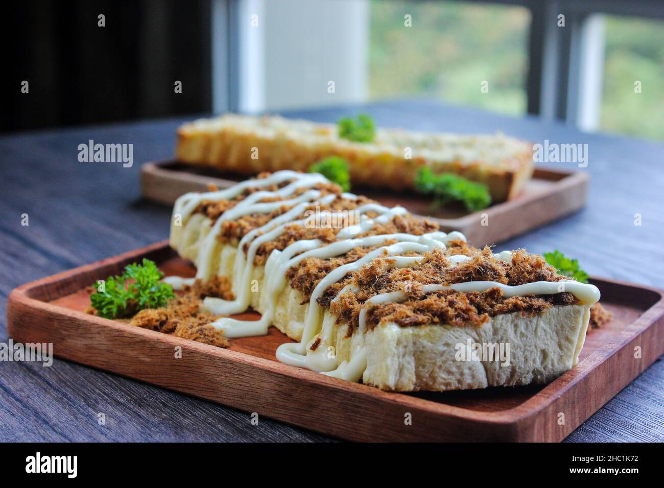 Seitenansicht Toast mit geschreddertem Rindfleisch gekrönt mit Mayonnaise. Serviert auf Holztabletts. Stockfoto