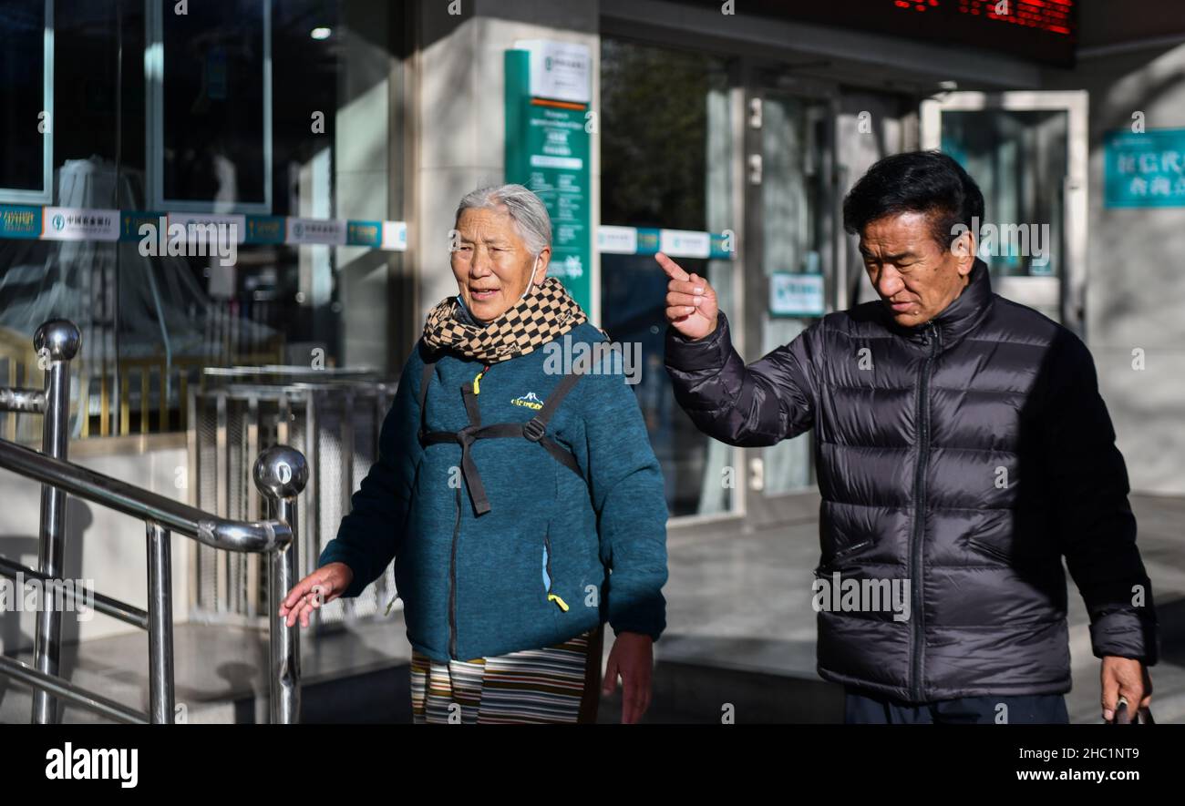 (211217) -- LHASA, 17. Dezember 2021 (Xinhua) -- Dawa Lhadron (L) und ein Freund gehen auf einer Straße in Lhasa, südwestlich der Autonomen Region Tibet, am 7. Dezember 2021. Dawa Lhadron, geboren 1945, lebt heute in Lhasa ein glückliches Leben. Es erscheint ihr jedoch wie ein Alptraum, auf das zurückzublicken, was sie als Leibeigene in ihrer Kindheit erlitten hatte. „der größte gefährliche Faktor für mich, Schafe für Leibeigene zu hüten, waren diese Adler, da sie dazu neigen, in den Himmel zu tauchen und die Lämmer wegzutragen“, sagte Dawa. Um sich gut um die Schafe zu kümmern, musste sie aus Angst vor möglichen Aggressionen von Adlern den Himmel im Auge behalten. Stockfoto