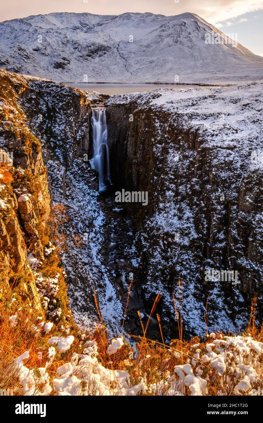 Ein Winterblick auf die Wailing Widow Falls, den Abfluss von Loch na Gainmhich im Assynt-Distrikt von Sutherland, Schottland, kurz vor Sonnenuntergang. Stockfoto