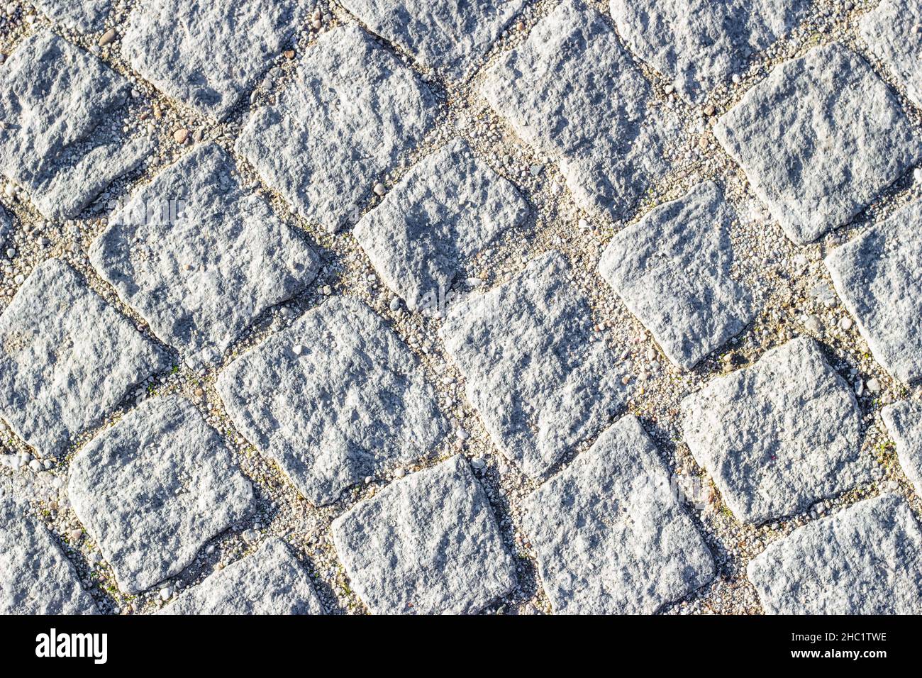 Hintergrundtextur aus Mauerwerk mit Sand in Nähten zwischen Pflastersteinen. Kreisförmige Linien, Draufsicht. Stockfoto