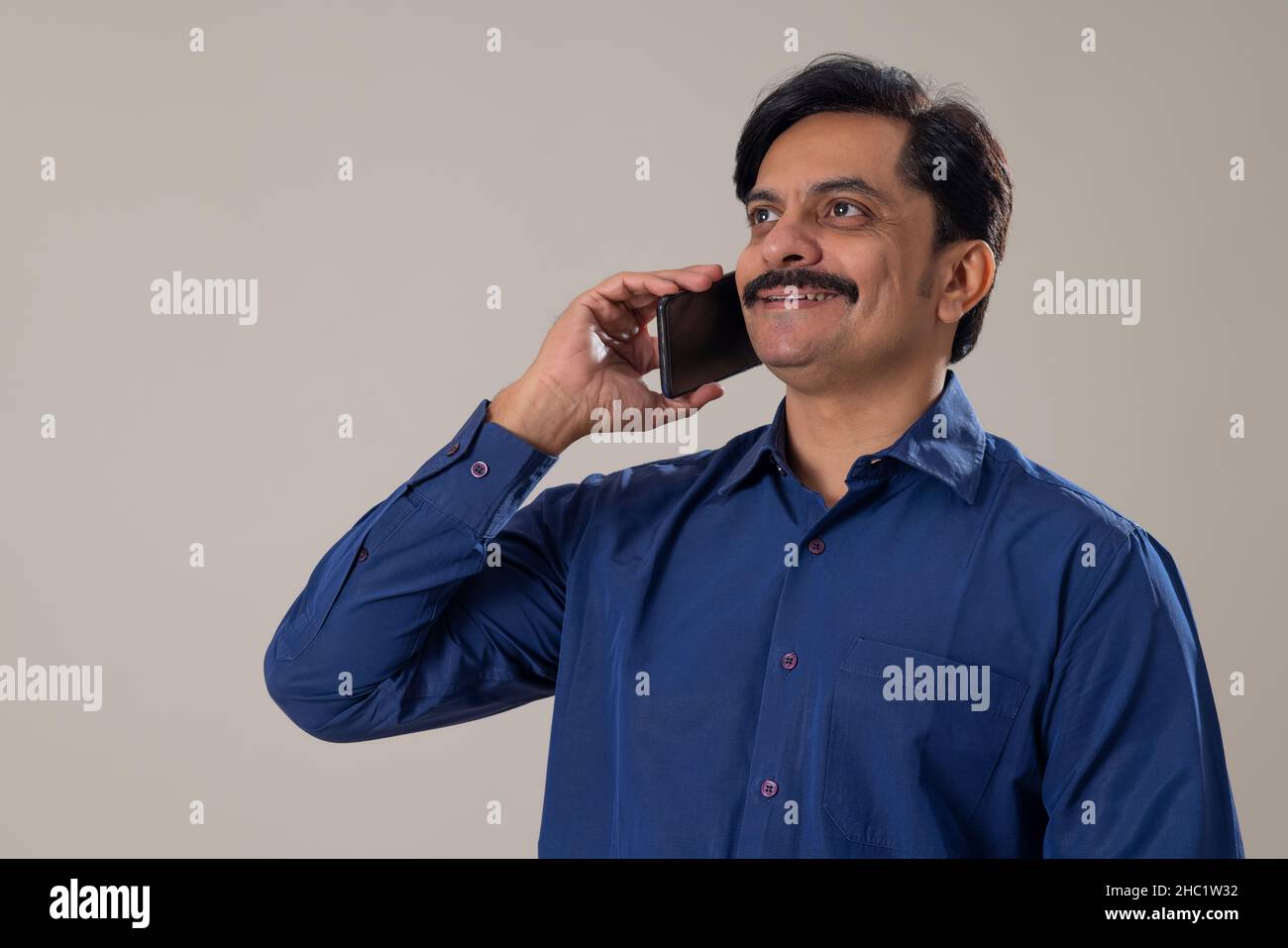 Seitenansicht eines Mannes mittleren Alters, der auf dem Smartphone spricht Stockfoto