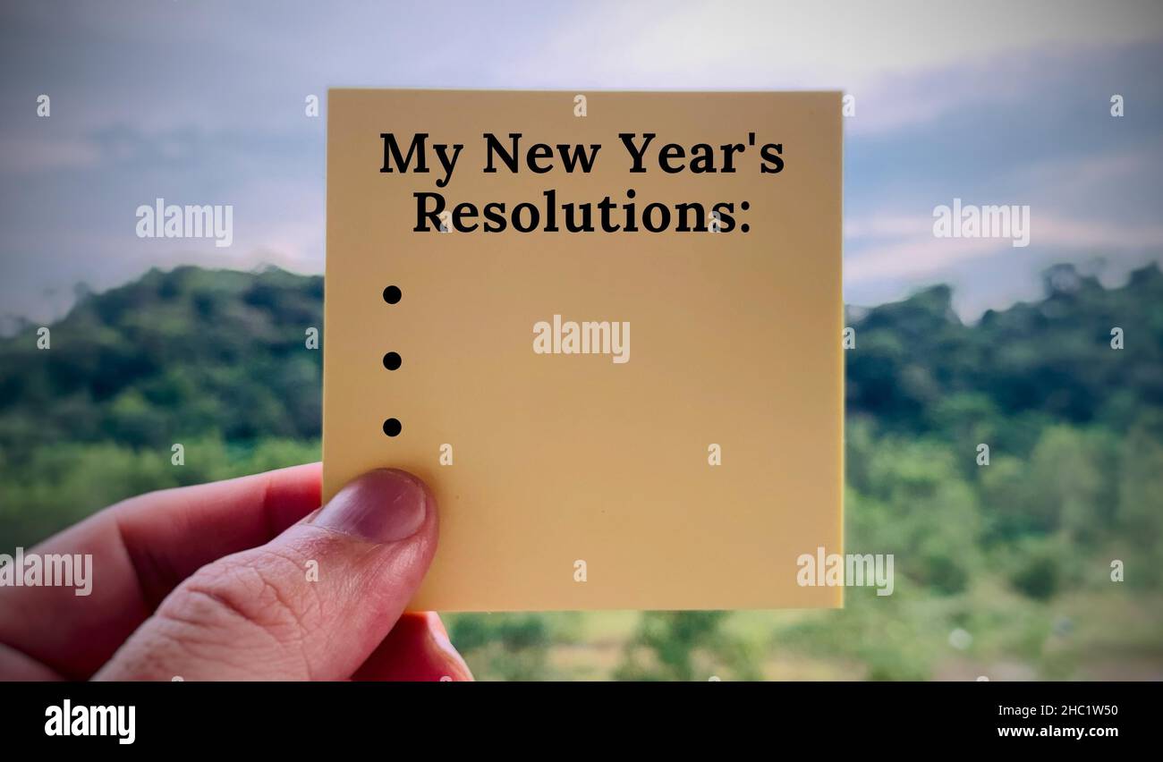 Bild mit den Auflösungen für das neue Jahr Text auf Haftnotiz mit verschwommenem Naturhintergrund geschrieben Stockfoto