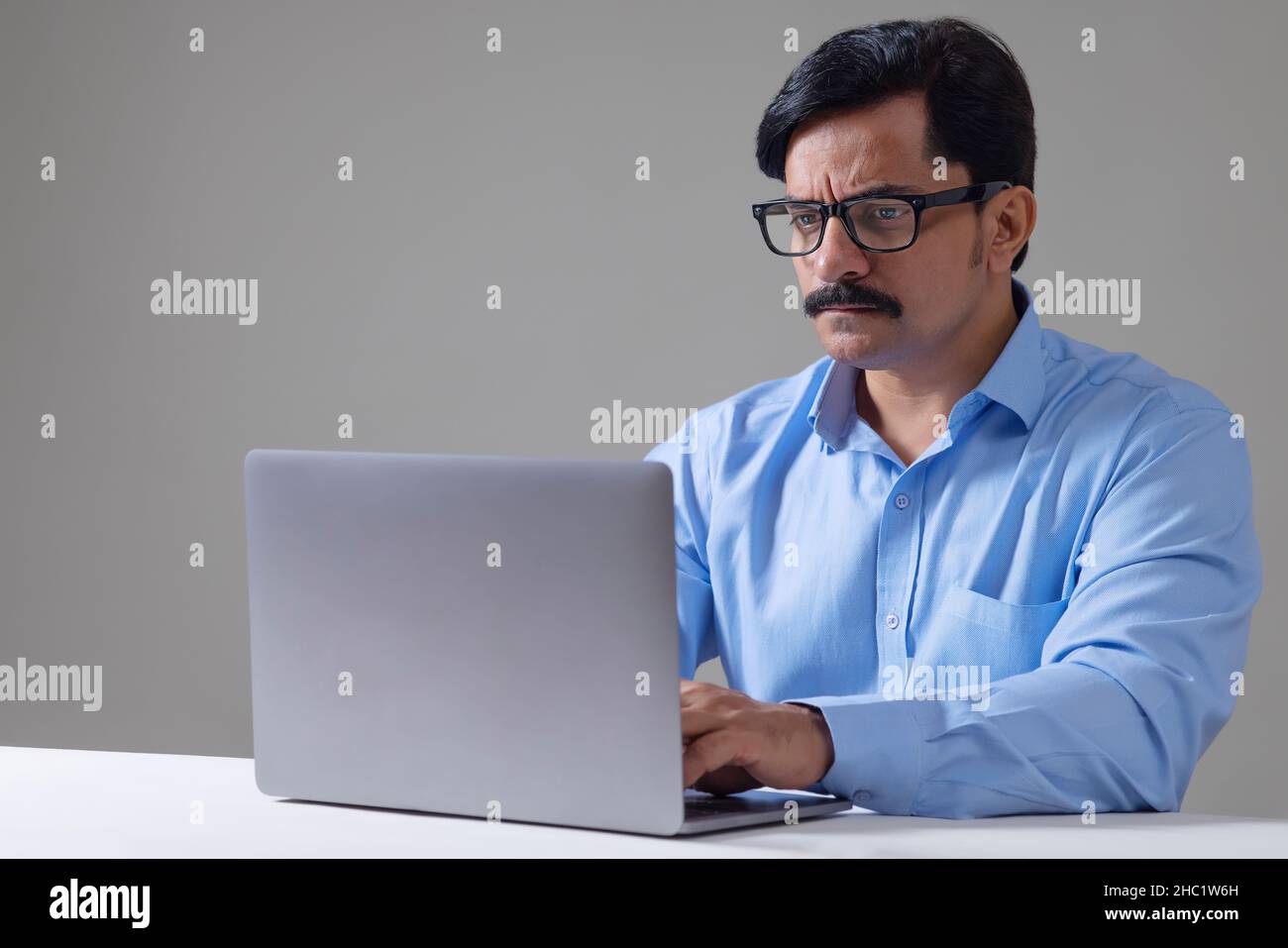 Mann in formeller Kleidung, der Büroarbeit mit Laptop macht Stockfoto
