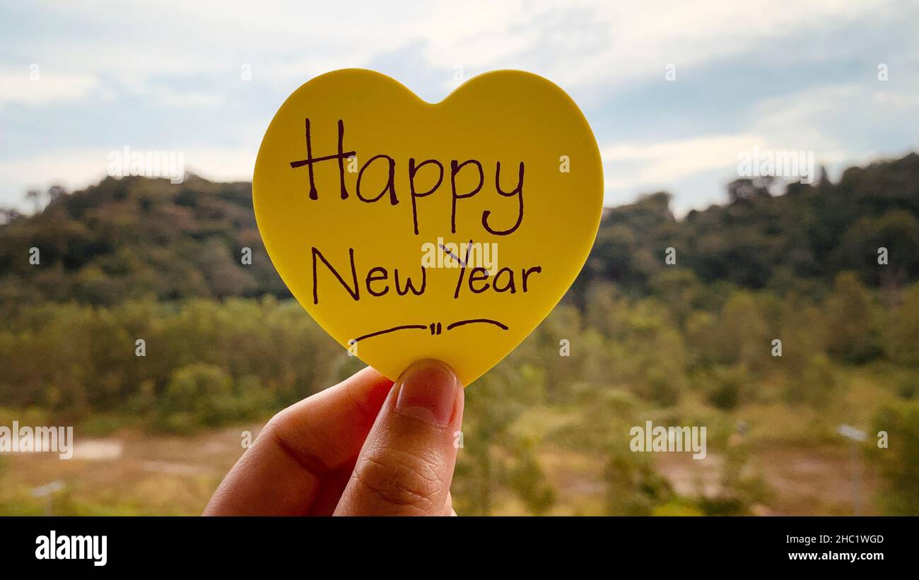 Frohes neues Jahr wünscht Text auf einem klebrigen Post IT-Notiz mit verschwommenem Hintergrund Natur Stockfoto