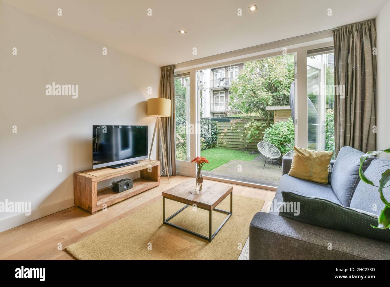 Einfache, teure Innenausstattung des Wohnzimmers mit Teppich und Beige Sofa Stockfoto